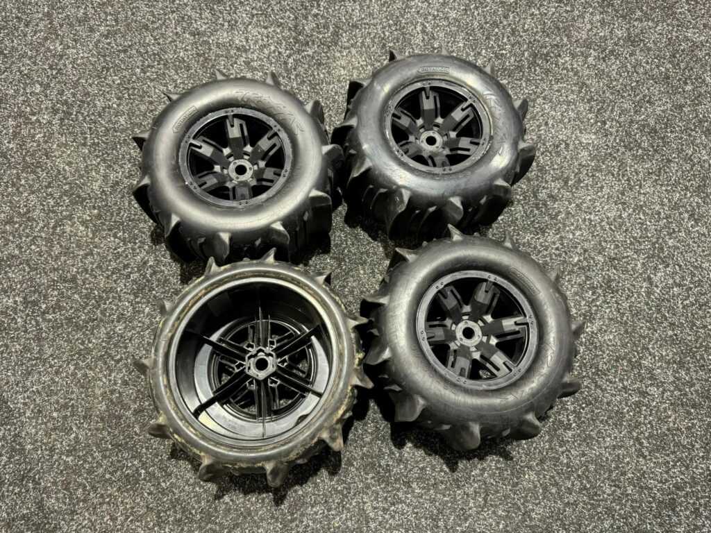 4x traxxas tires & wheels assembled glued (x maxx black wheels, paddle tires, foam inserts) (left & right) (2) – trx7773 (2 banden zijn perfect en de andere 2 zitten wat vol met zand)!